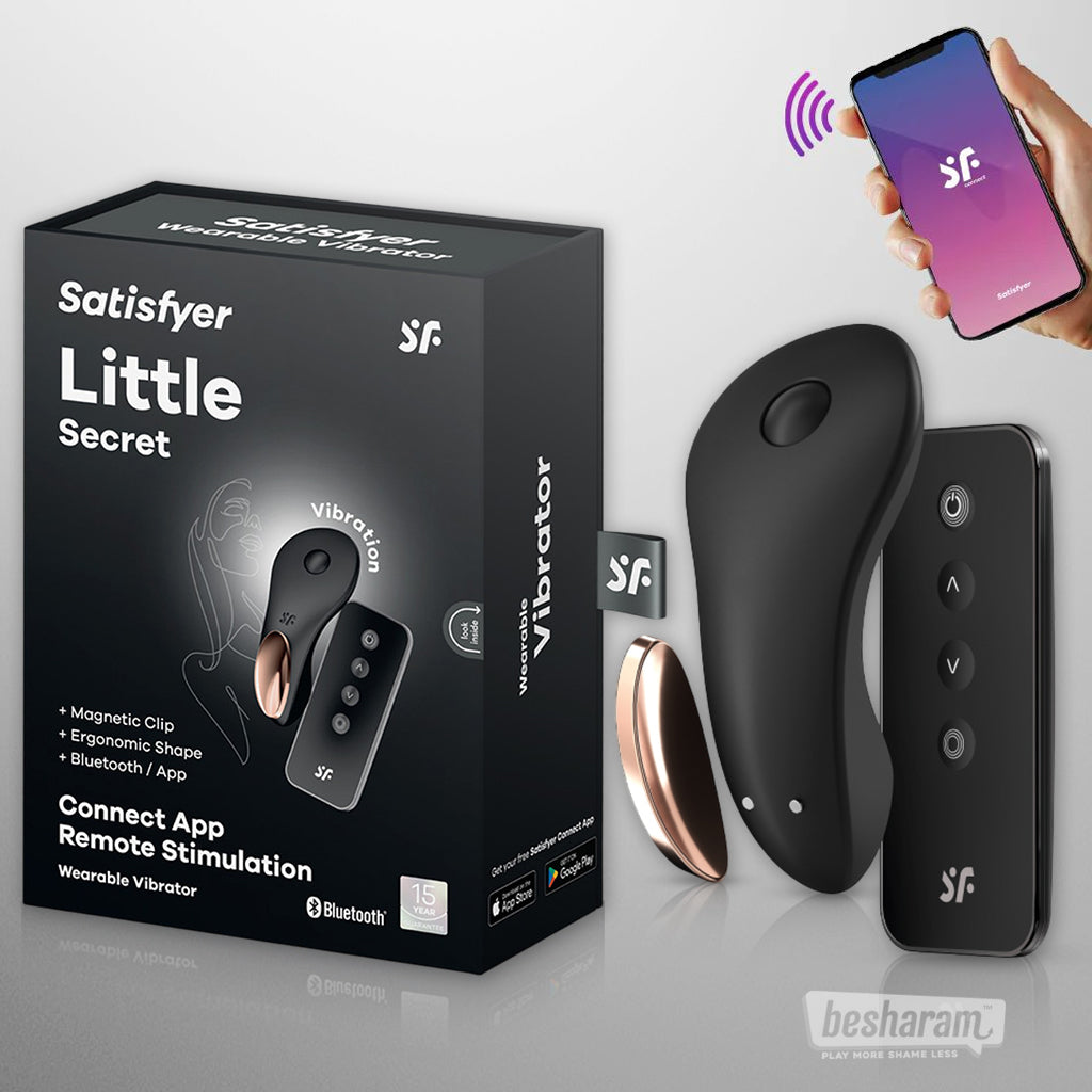 Black Satisfyer Little Secret wearable vibrator with rose gold accent shown with remote control, mobile app on smartphone, and product box on a light background