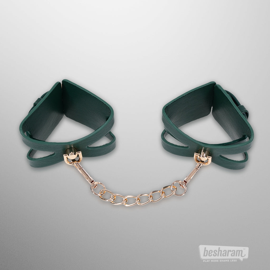 Green Indica cutout cuffs connected with gold chain by Sex & Mischief