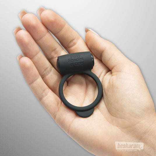 Woman holding Fifty Shades of Grey vibrating cock ring in hand – black silicone ring for couples pleasure, available at IMBesharam.com.