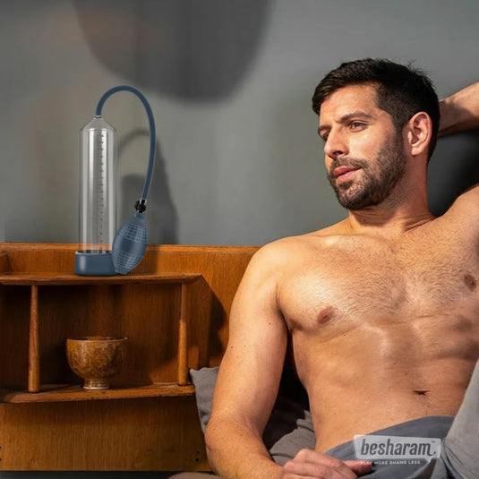 Boners manual penis pump placed on bedside table next to a man relaxing on the bed