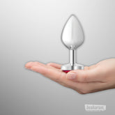 Viben Cheeky Charms silver heart butt plug displayed on an open palm showing smooth metal finish