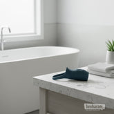 Boners vibrating penis sleeve displayed on bathroom counter near bathtub and towels