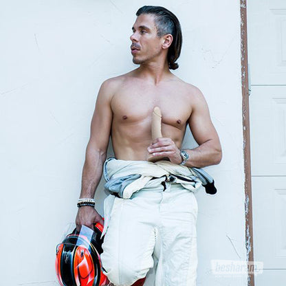 Realistic Mick Blue silicone dildo held in hand showing life size proportions and firm base design in lifestyle setting