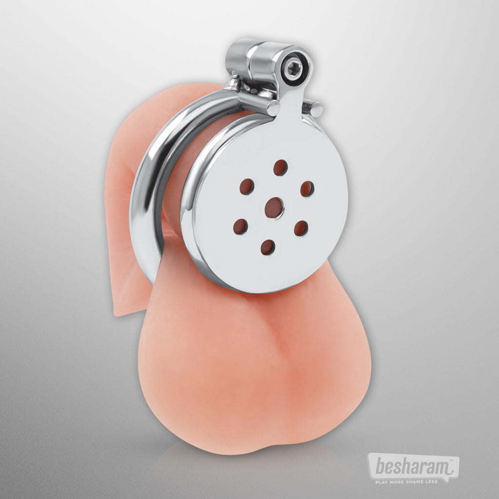 Front view of the stainless steel chastity cage placed on anatomical display for sizing reference.