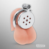 Front view of the stainless steel chastity cage placed on anatomical display for sizing reference.