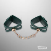 Green Indica cutout cuffs connected with gold chain by Sex & Mischief
