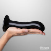 Curved black P and G spot dildo size L resting on a hand to demonstrate size.