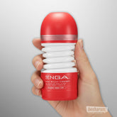 Tenga Rolling Head Cup masturbator held in hand showing compact ribbed design