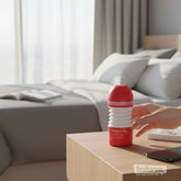 Tenga Rolling Head Cup masturbator placed on bedside table in a modern bedroom setting