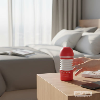 Tenga Rolling Head Cup masturbator placed on bedside table in a modern bedroom setting