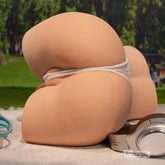 Side view of torso sex doll placed on blanket in outdoor themed setup